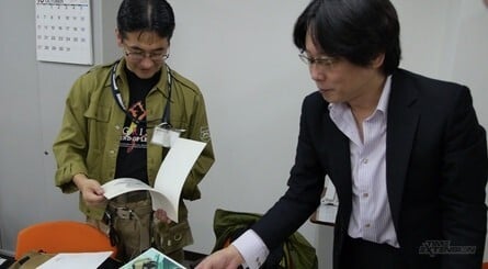 Masayuki Suzuki (in the green jacket) and Satoshi Nakai (in the suit) leaf through some artwork relating to their past titles