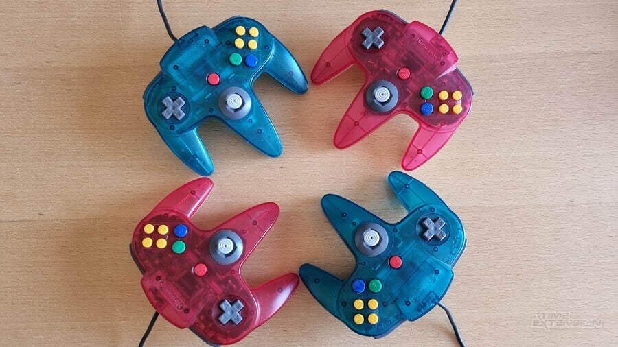 Alternating red and blue transparent N64 controllers in a circle.